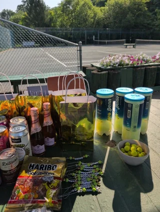 Prize table with gift bags, drinks and tubes of tennis balls