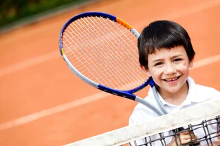 Young boy playing tennis during a lesson